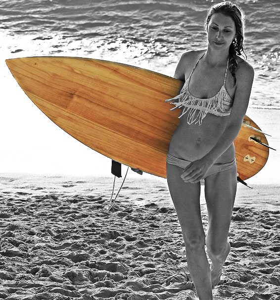 surfer girl walking up beach