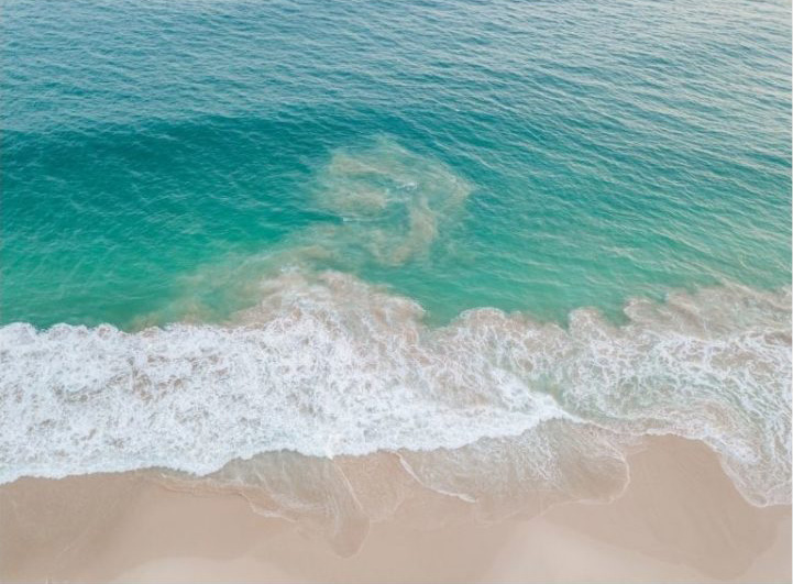 Water discoloured by sand being pulled out to sea in a rip current